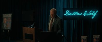 Movie still from “Imperium” (2016), directed by Daniel Ragussis – An older man standing at a podium in front of a laptop; Medium shot, Over the shoulder angle