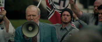 Movie still from “Imperium” (2016), directed by Daniel Ragussis – A man with a megaphone in front of another man; Medium shot, Over the shoulder angle