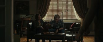 Movie still from “Imperium” (2016), directed by Daniel Ragussis – Two people sitting on a couch playing a board game; Wide shot, Over the shoulder angle