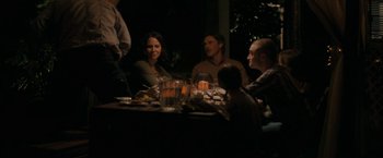 Movie still from “Imperium” (2016), directed by Daniel Ragussis – A group of people sitting around a table at night; Medium shot, High angle