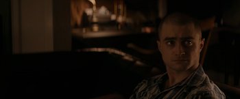 Movie still from “Imperium” (2016), directed by Daniel Ragussis – A man sitting on a couch in a dark room; Close Up shot, High angle