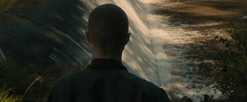 Movie still from “Imperium” (2016), directed by Daniel Ragussis – A man standing in front of a waterfall looking into the distance; Close Up shot, Over the shoulder angle