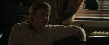 Movie still from “Imperium” (2016), directed by Daniel Ragussis – A person sitting on a couch; Close Up shot, Over the shoulder angle
