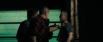 Movie still from “Imperium” (2016), directed by Daniel Ragussis – Two men are fighting in front of a green wall; Medium shot, Over the shoulder angle