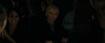Movie still from “Imperium” (2016), directed by Daniel Ragussis – A woman in a black jacket is smiling for the camera; Medium shot, High angle