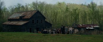Movie still from “In Dubious Battle” (2016), directed by James Franco – A group of people standing in front of an old house; Extreme Wide shot, Low angle