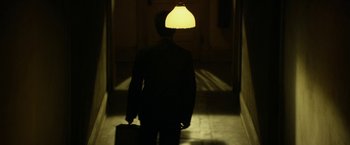 Movie still from “In Dubious Battle” (2016), directed by James Franco – A person walking down a hallway with a suitcase; Wide shot, High angle