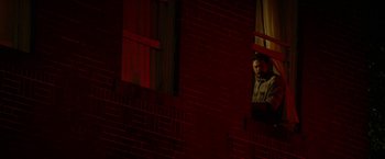 Movie still from “In Dubious Battle” (2016), directed by James Franco – A man is looking out of a window at night; Wide shot, Low angle