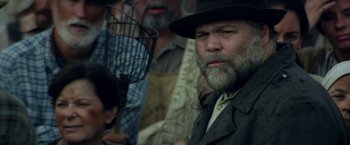 Movie still from “In Dubious Battle” (2016), directed by James Franco – A man with a beard and a hat is holding a fan; Close Up shot, Low angle