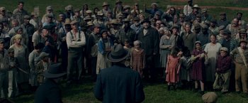 Movie still from “In Dubious Battle” (2016), directed by James Franco – A group of people standing in a grassy field; Wide shot, High angle