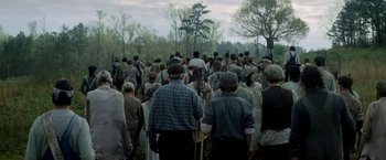 Movie still from “In Dubious Battle” (2016), directed by James Franco – A large group of people standing in a field; Wide shot, High angle