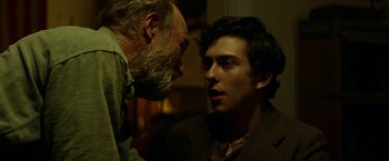 Movie still from “In Dubious Battle” (2016), directed by James Franco – A man standing next to another man in a room; Close Up shot, Over the shoulder angle