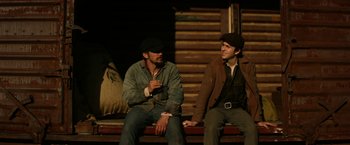 Movie still from “In Dubious Battle” (2016), directed by James Franco – A couple of men sitting next to each other on top of a bench; Medium shot, High angle