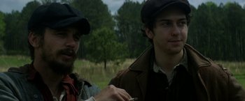 Movie still from “In Dubious Battle” (2016), directed by James Franco – Two men are standing in a field with trees in the background; Close Up shot, Over the shoulder angle