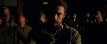 Movie still from “In Dubious Battle” (2016), directed by James Franco – A person with a beard in the dark; Close Up shot, Over the shoulder angle