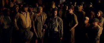Movie still from “In Dubious Battle” (2016), directed by James Franco – A group of people standing around in a room; Medium shot, Low angle