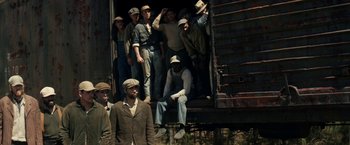 Movie still from “In Dubious Battle” (2016), directed by James Franco – A group of men standing next to each other on top of a train car; Wide shot, High angle