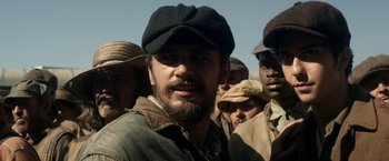 Movie still from “In Dubious Battle” (2016), directed by James Franco – A group of men standing next to each other in a field; Close Up shot, Over the shoulder angle
