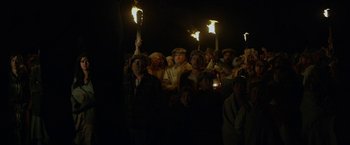 Movie still from “In Dubious Battle” (2016), directed by James Franco – A group of people holding torches in the dark; Wide shot, High angle