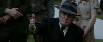Movie still from “In Dubious Battle” (2016), directed by James Franco – An older man in a suit and hat giving a thumbs up; Close Up shot, Over the shoulder angle