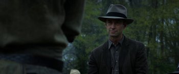 Movie still from “In Dubious Battle” (2016), directed by James Franco – A man wearing a hat and a suit; Close Up shot, Over the shoulder angle
