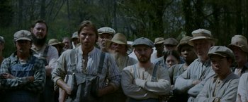 Movie still from “In Dubious Battle” (2016), directed by James Franco – A group of people standing next to each other in a forest; Medium shot, Over the shoulder angle