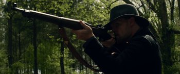 Movie still from “In Dubious Battle” (2016), directed by James Franco – A man with a hat and a rifle in the woods; Close Up shot, Over the shoulder angle