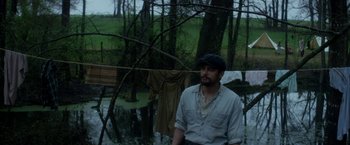 Movie still from “In Dubious Battle” (2016), directed by James Franco – A man standing in front of some trees; Medium shot, Over the shoulder angle
