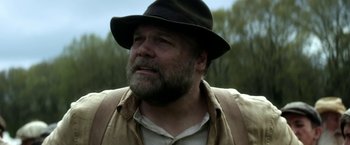 Movie still from “In Dubious Battle” (2016), directed by James Franco – A person wearing a hat with trees in the background; Close Up shot, Low angle