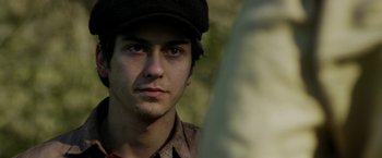 Movie still from “In Dubious Battle” (2016), directed by James Franco – A young man wearing a hat and looking at the camera; Close Up shot, Over the shoulder angle