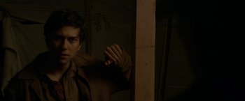 Movie still from “In Dubious Battle” (2016), directed by James Franco – A man standing next to a wooden pole; Medium shot, Over the shoulder angle