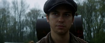 Movie still from “In Dubious Battle” (2016), directed by James Franco – A young man wearing a hat and looking at the camera; Close Up shot, Low angle