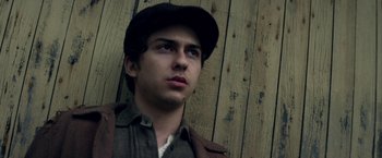 Movie still from “In Dubious Battle” (2016), directed by James Franco – A young man wearing a hat looking to his left; Close Up shot, Low angle