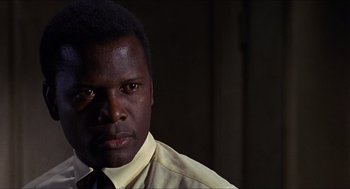 Movie still from “In the Heat of the Night” (1967), directed by Norman Jewison – A person wearing a dress shirt and tie; Close Up shot, Low angle