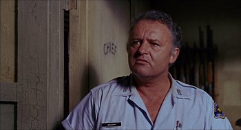 Movie still from “In the Heat of the Night” (1967), directed by Norman Jewison – An older man wearing a uniform in front of a wall; Close Up shot, Low angle