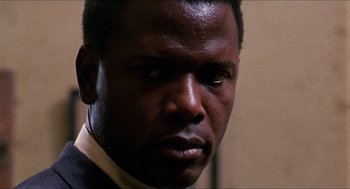Movie still from “In the Heat of the Night” (1967), directed by Norman Jewison – A person wearing a suit and tie; Close Up shot, Low angle