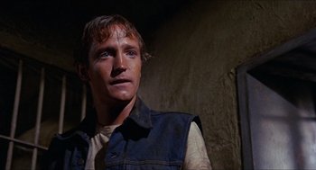 Movie still from “In the Heat of the Night” (1967), directed by Norman Jewison – A man in a blue vest looking to his left; Close Up shot, Low angle