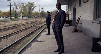 Movie still from “In the Heat of the Night” (1967), directed by Norman Jewison – A man in a suit standing next to another man in a suit; Wide shot, Low angle