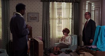 Movie still from “In the Heat of the Night” (1967), directed by Norman Jewison – A woman sitting on a chair in a room; Medium shot, High angle