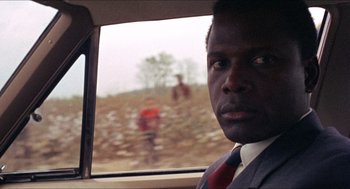 Movie still from “In the Heat of the Night” (1967), directed by Norman Jewison – A man in a suit looking out of a car window; Close Up shot, Over the shoulder angle