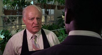 Movie still from “In the Heat of the Night” (1967), directed by Norman Jewison – An older man wearing a suit and tie talking to a younger man; Close Up shot, Over the shoulder angle