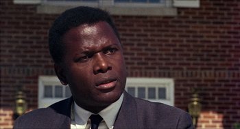 Movie still from “In the Heat of the Night” (1967), directed by Norman Jewison – A man in a suit and tie looking to his left; Close Up shot, Low angle