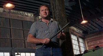 Movie still from “In the Heat of the Night” (1967), directed by Norman Jewison – A man holding a stick in his hands; Medium shot, Low angle