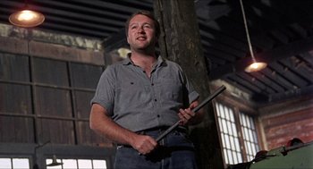 Movie still from “In the Heat of the Night” (1967), directed by Norman Jewison – A man holding a stick in his hands; Medium shot, Low angle