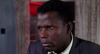 Movie still from “In the Heat of the Night” (1967), directed by Norman Jewison – A person wearing a suit and tie; Close Up shot, High angle