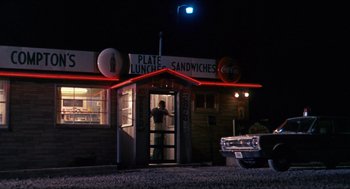 Movie still from “In the Heat of the Night” (1967), directed by Norman Jewison – A man standing in front of a restaurant at night; Extreme Wide shot, Low angle