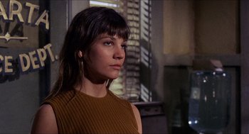 Movie still from “In the Heat of the Night” (1967), directed by Norman Jewison – A woman in a brown top is standing in a room; Close Up shot, Low angle