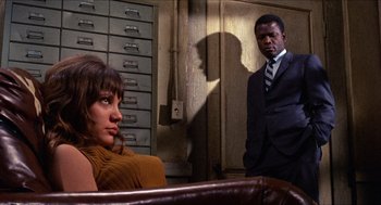 Movie still from “In the Heat of the Night” (1967), directed by Norman Jewison – A man and a woman standing next to each other in a room; Medium shot, Low angle