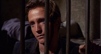 Movie still from “In the Heat of the Night” (1967), directed by Norman Jewison – A person behind a fence; Close Up shot, High angle