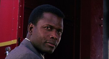 Movie still from “In the Heat of the Night” (1967), directed by Norman Jewison – A person wearing a suit and tie; Close Up shot, Low angle